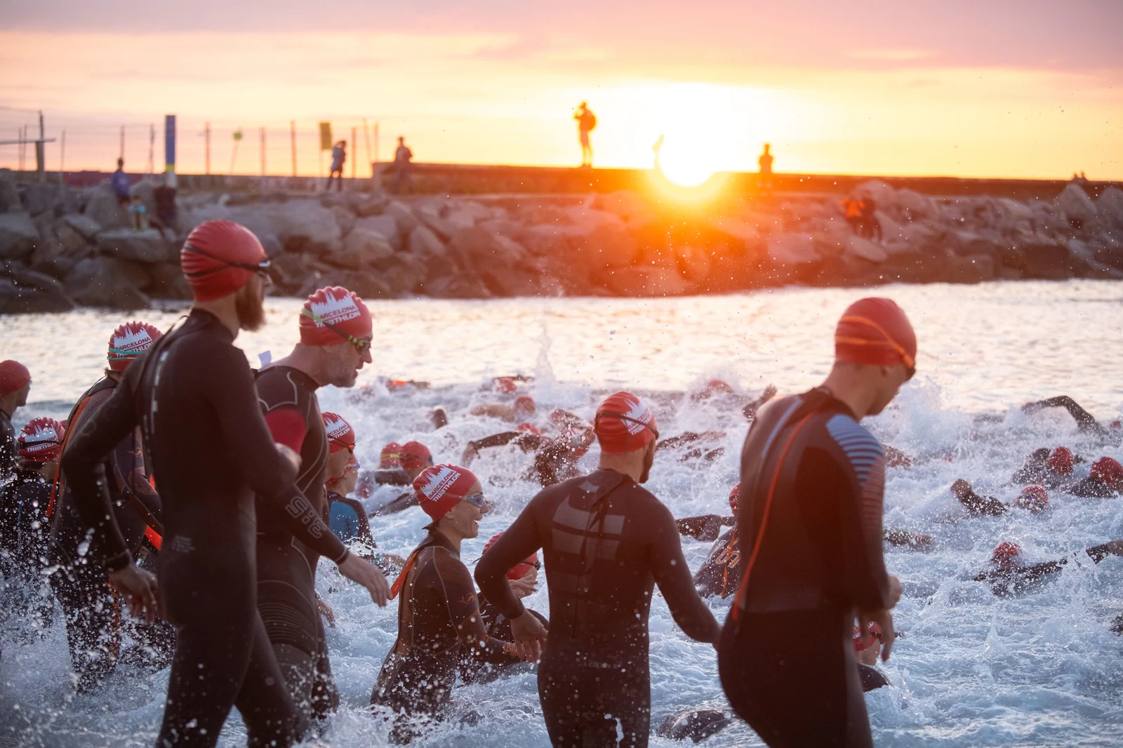 Barcelona Triathlon participants entering the sea at sunrise